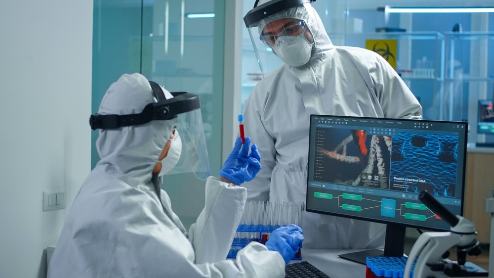 professional-chemists-ppe-suit-analysing-vaccine-development-pointing-pc-display-equipped-laboratory professional-chemists-ppe-suit-analysing-vaccine-development-pointing-pc-display-equipped-laboratory